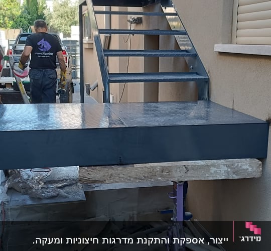 גרם מדרגות מתכת מותקן לצד קיר חיצוני